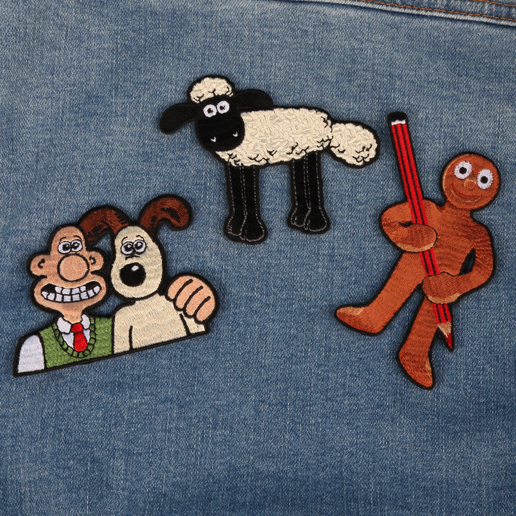 Aardman character sew on patches on a denim jacket. Features Wallace & Gromit, Shaun the Sheep and Morph holding a pencil. 