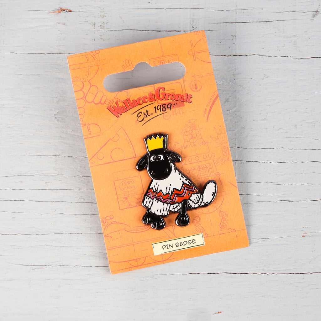 Enamel pin badge of Shaun the Sheep wearing a wooly jumper and crown. 