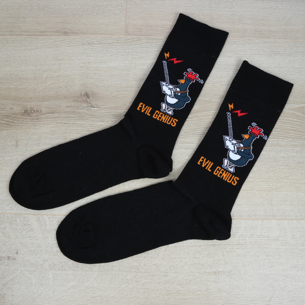 Black socks with Feathers McGraw 'Evil Genius' design on a wooden surface