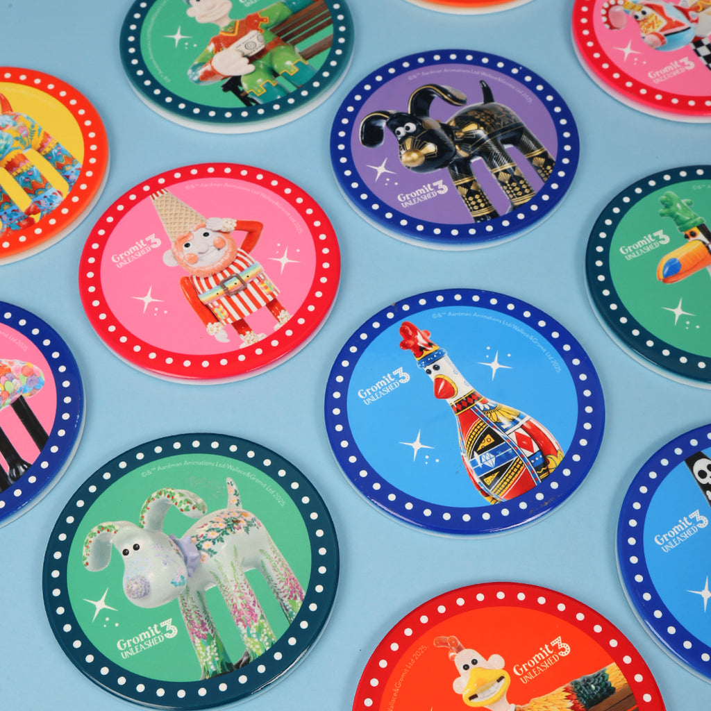 Colourful coasters with Gromit Unleashed 3 sculpture designs on a blue background
