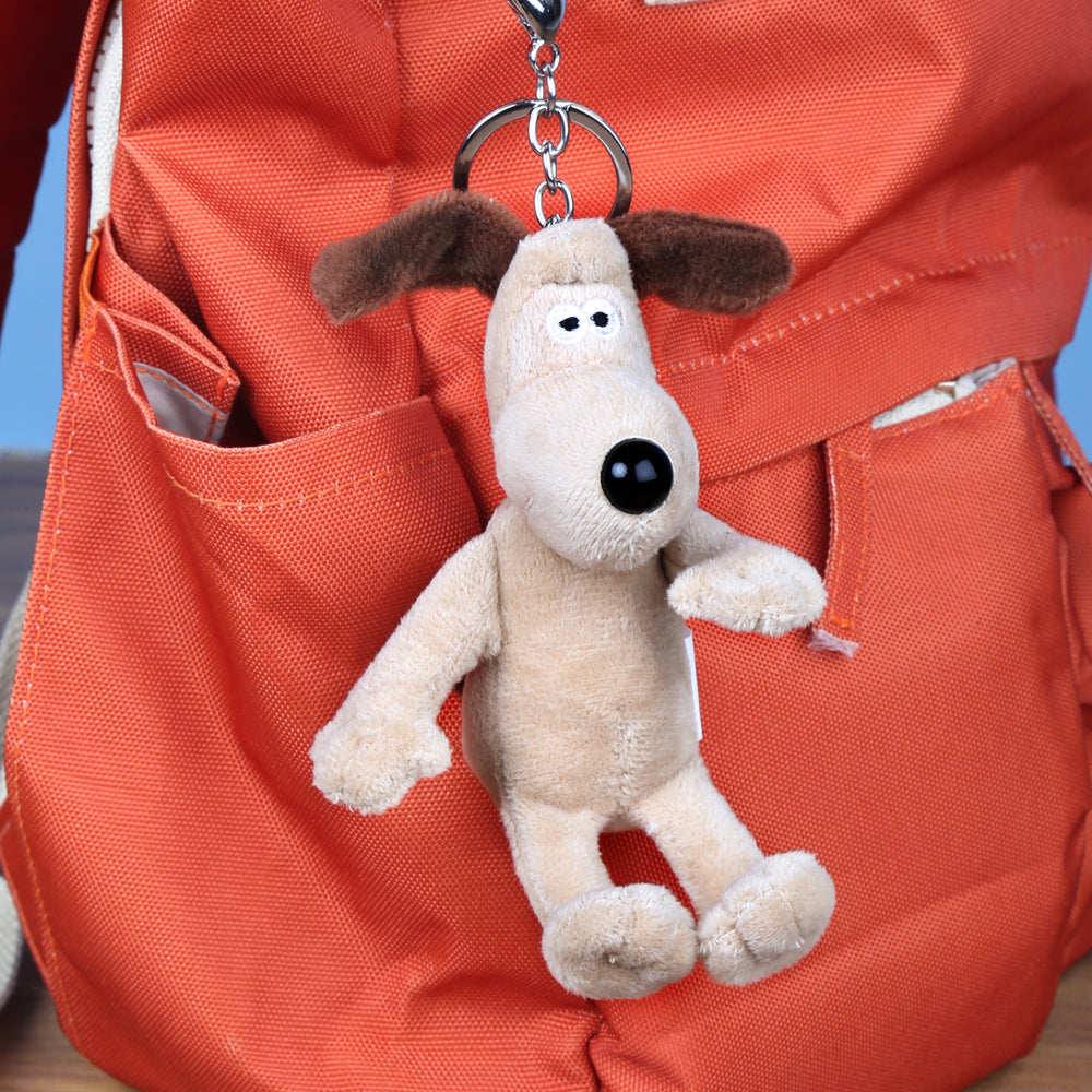 Small Gromit soft toy, on bag clip or keyring, attached to orange rucksack