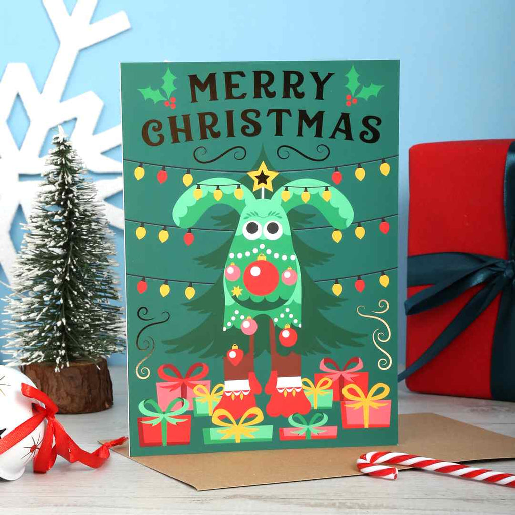 Christmas card with a green Noel Christmas Gromit, presents, and lights on a blue background