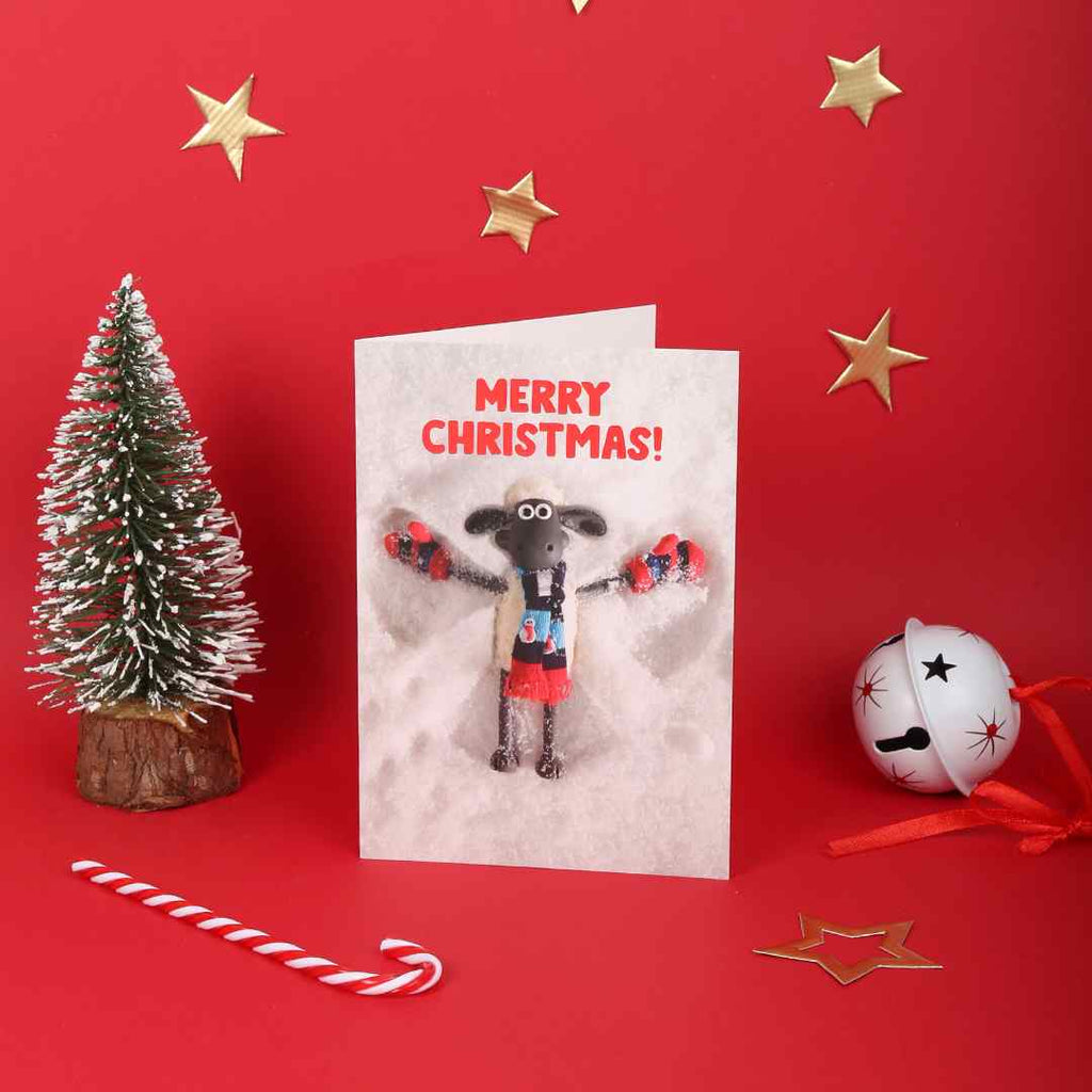 A Christmas card with a Shaun the Sheep on a red background with festive decorations.