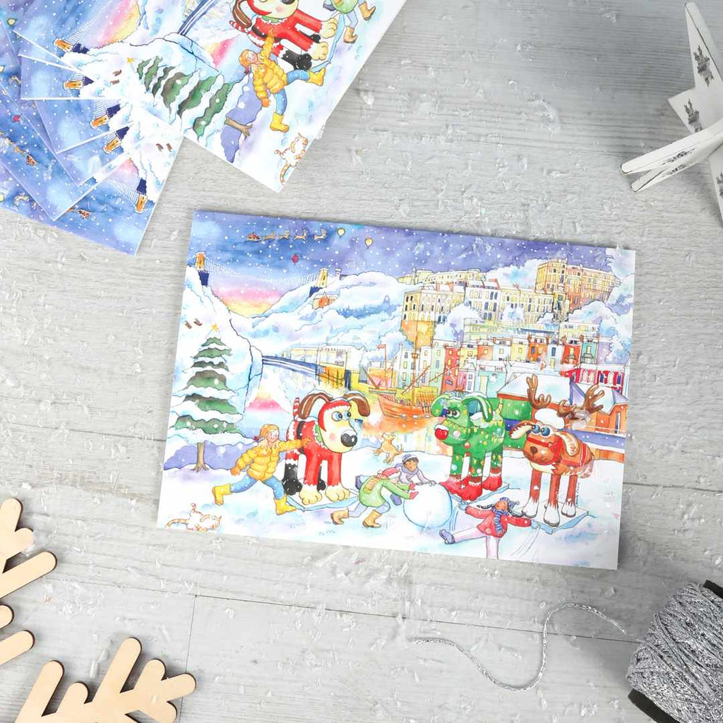 Snowy Gromit Christmas card pack on a wooden background.
