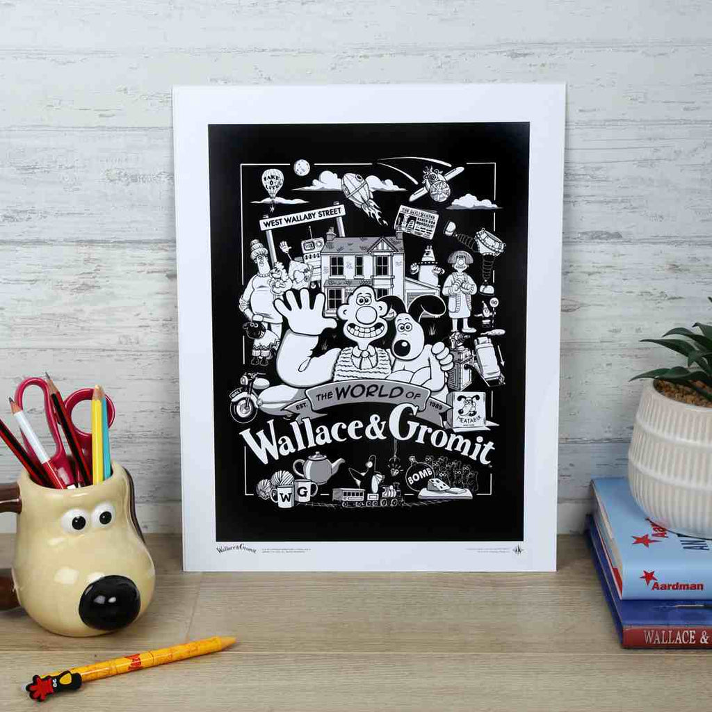 Unframed artwork of 'The World of Wallace & Gromit' on a wooden surface with stationery items.