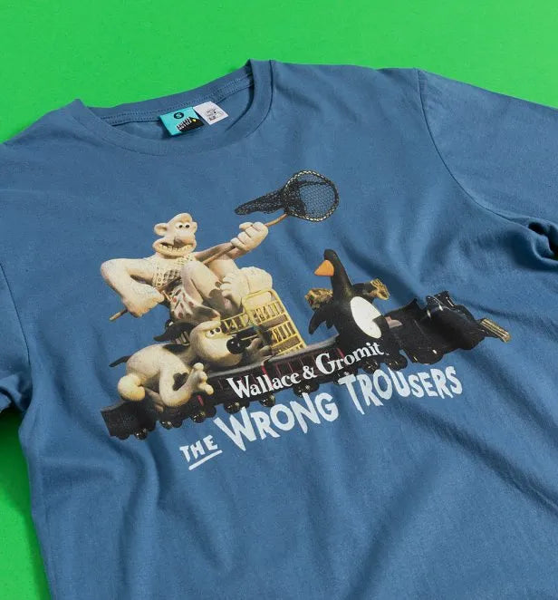 Blue t-shirt featuring the classic chase scene from Aardman's film Wallace & Gromit's: The Wrong Trousers. Features Wallace, Gromit and Feathers McGraw on a toy train, Wallace trying to catch Feathers with a net. 