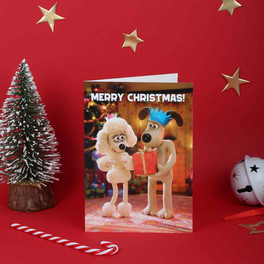 Christmas card with Fluffles and Gromit sharing a gift on a red background with decorative elements