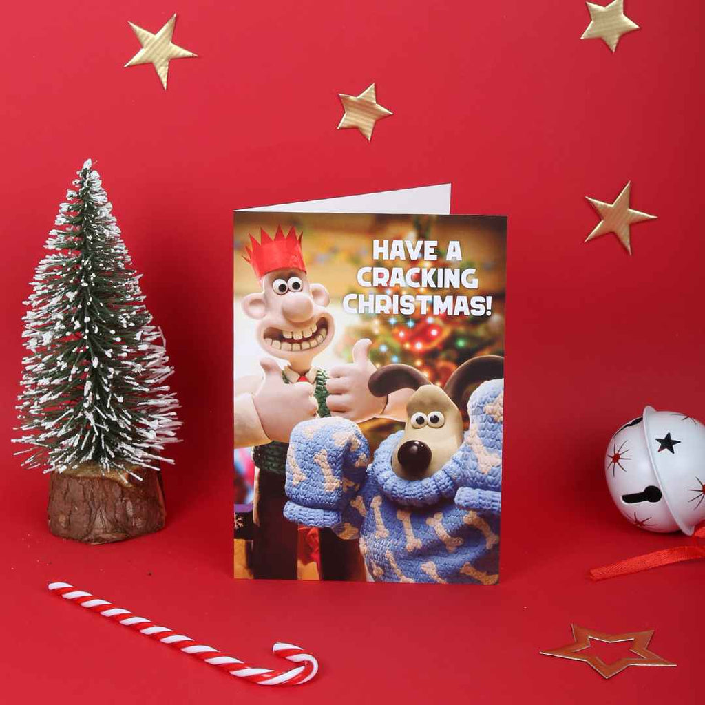 Christmas card with Wallace and Gromit  on a red background with festive decorations