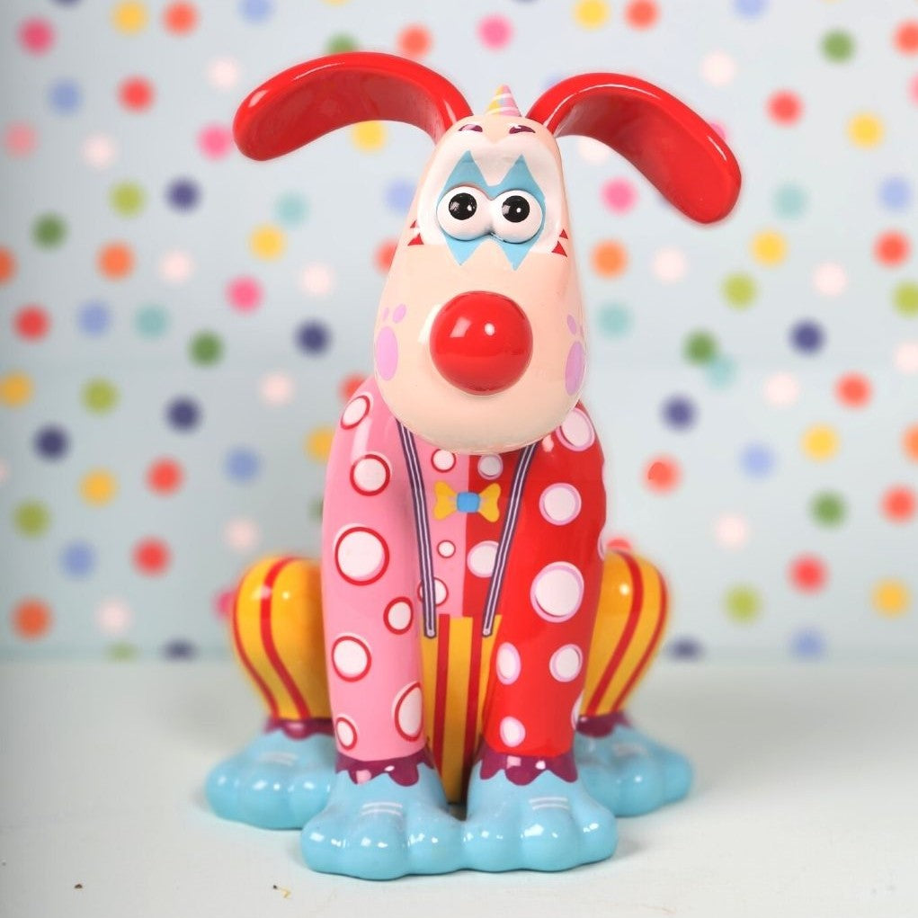 Giggles the Clown figurine, Gromit with spotty top and striped red and yellow trousers, bright red nose, blues shoes and party hat