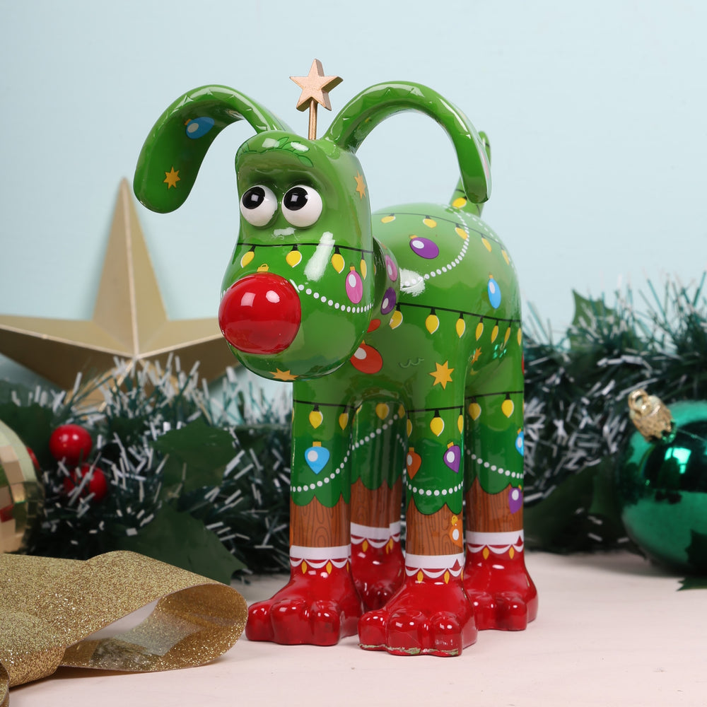 Noël Gromit Figurine sat amoungst Christmas decorations 